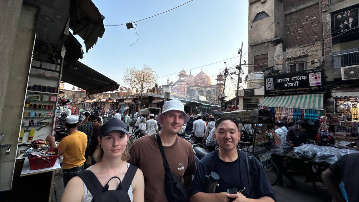 Tourists exploring Old Delhi market near Jama Masjid during a 3 Days Golden Triangle Tour in India with local street life and historic mosque in background.